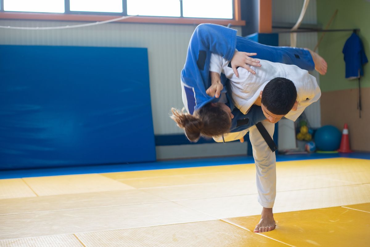 Two judokas practising a throw on tatami mats during training