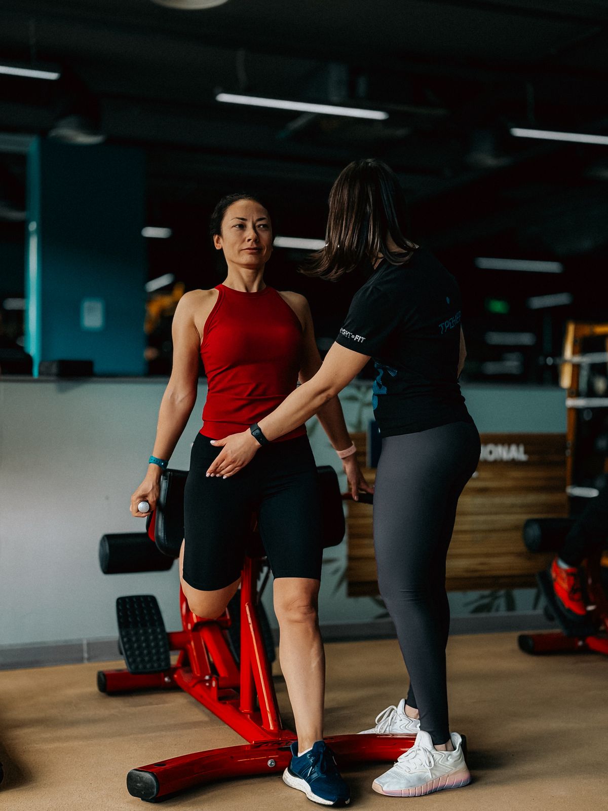 A personal trainer coaching a client during a session in a gym
